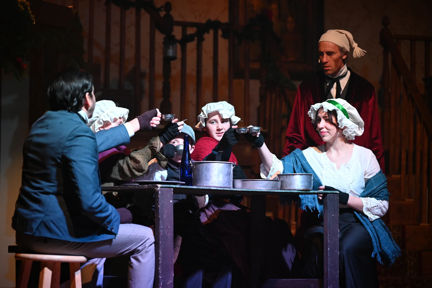 The Cratchit family raises a toast around the Christmas dinner table in 2025.