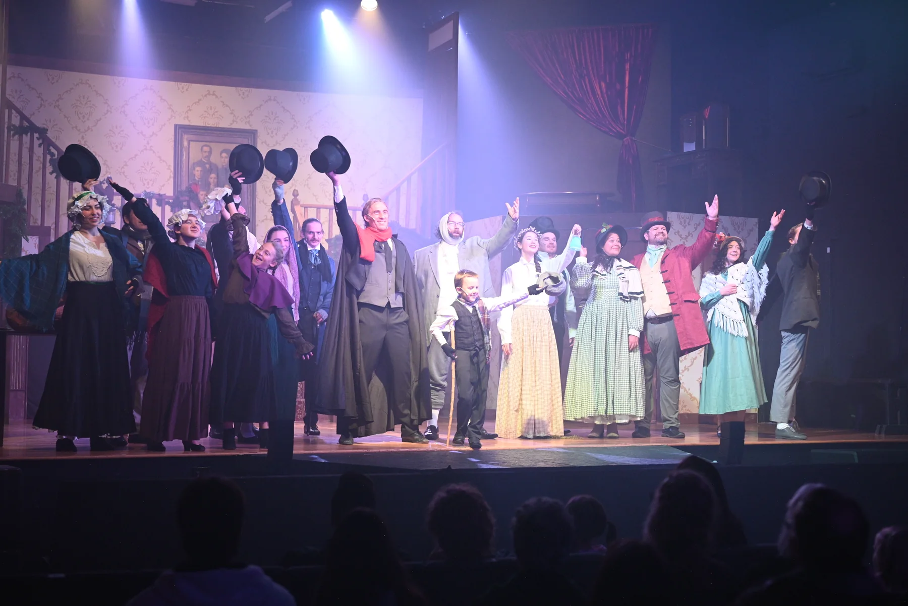 The 2025 cast celebrates together with hats raised in the musical finale.